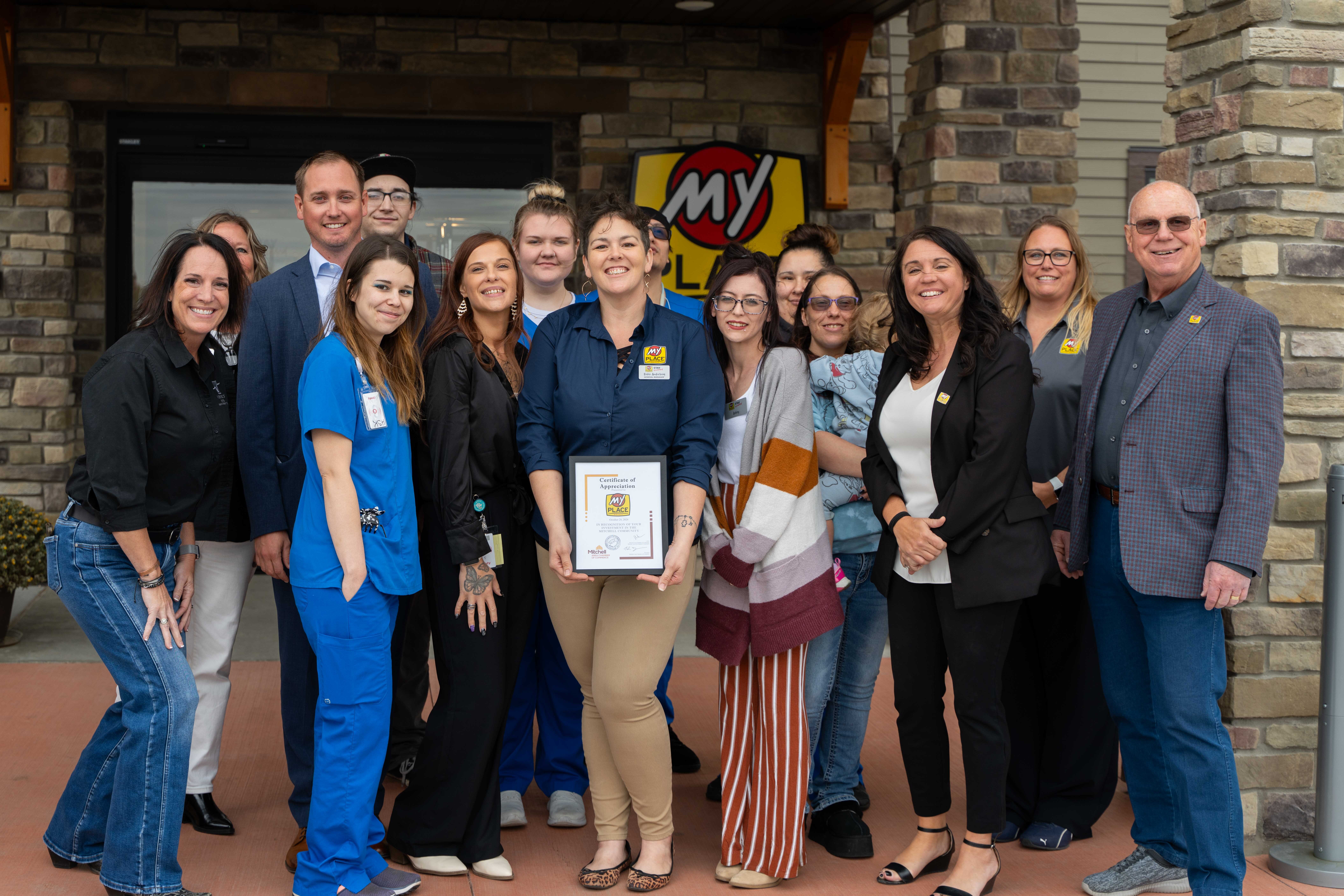 A small group of people pose for the camera outside of My Place Hotel in Mitchell, SD.