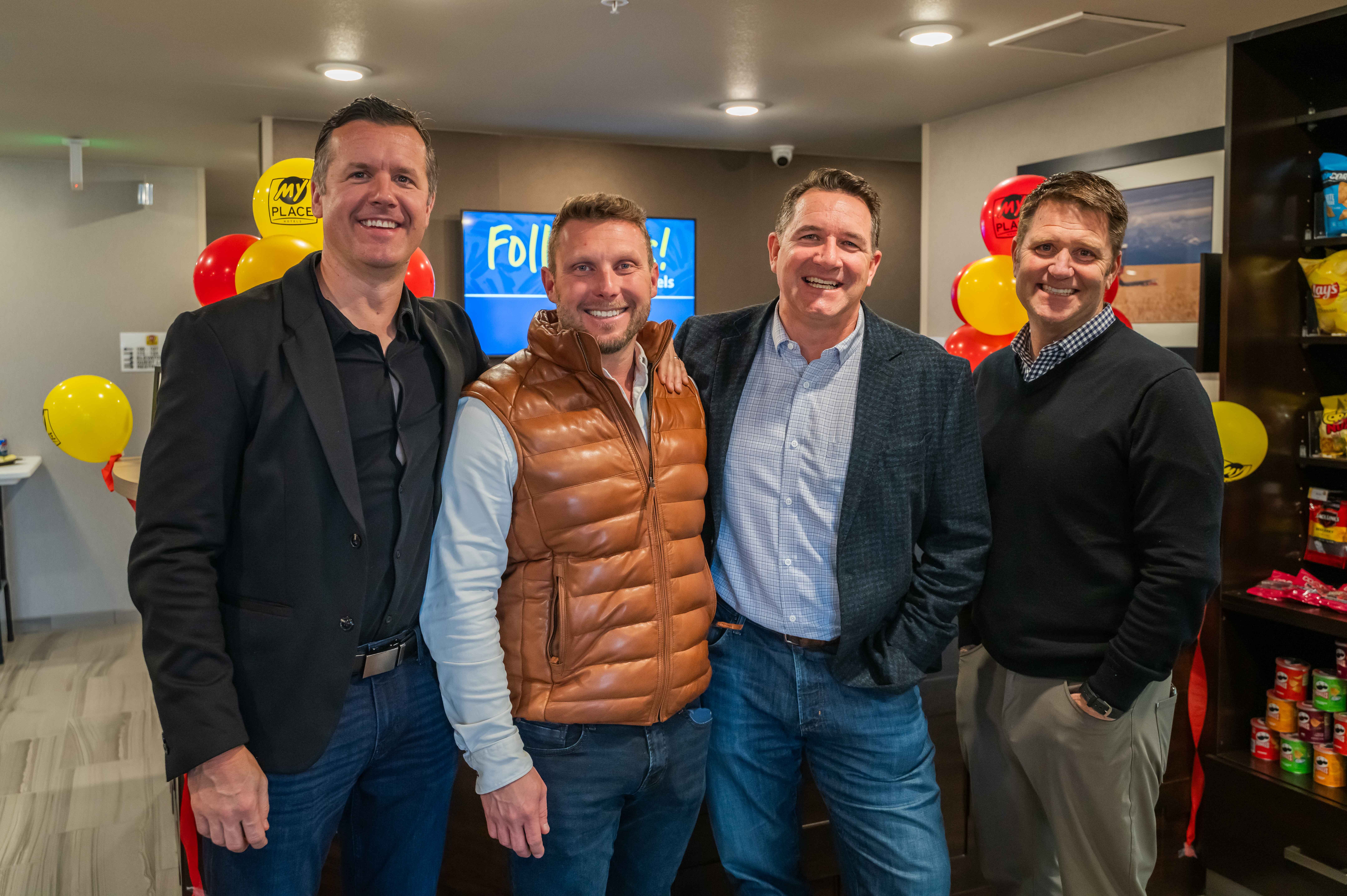 four men standing together in a My Place Hotel lobby
