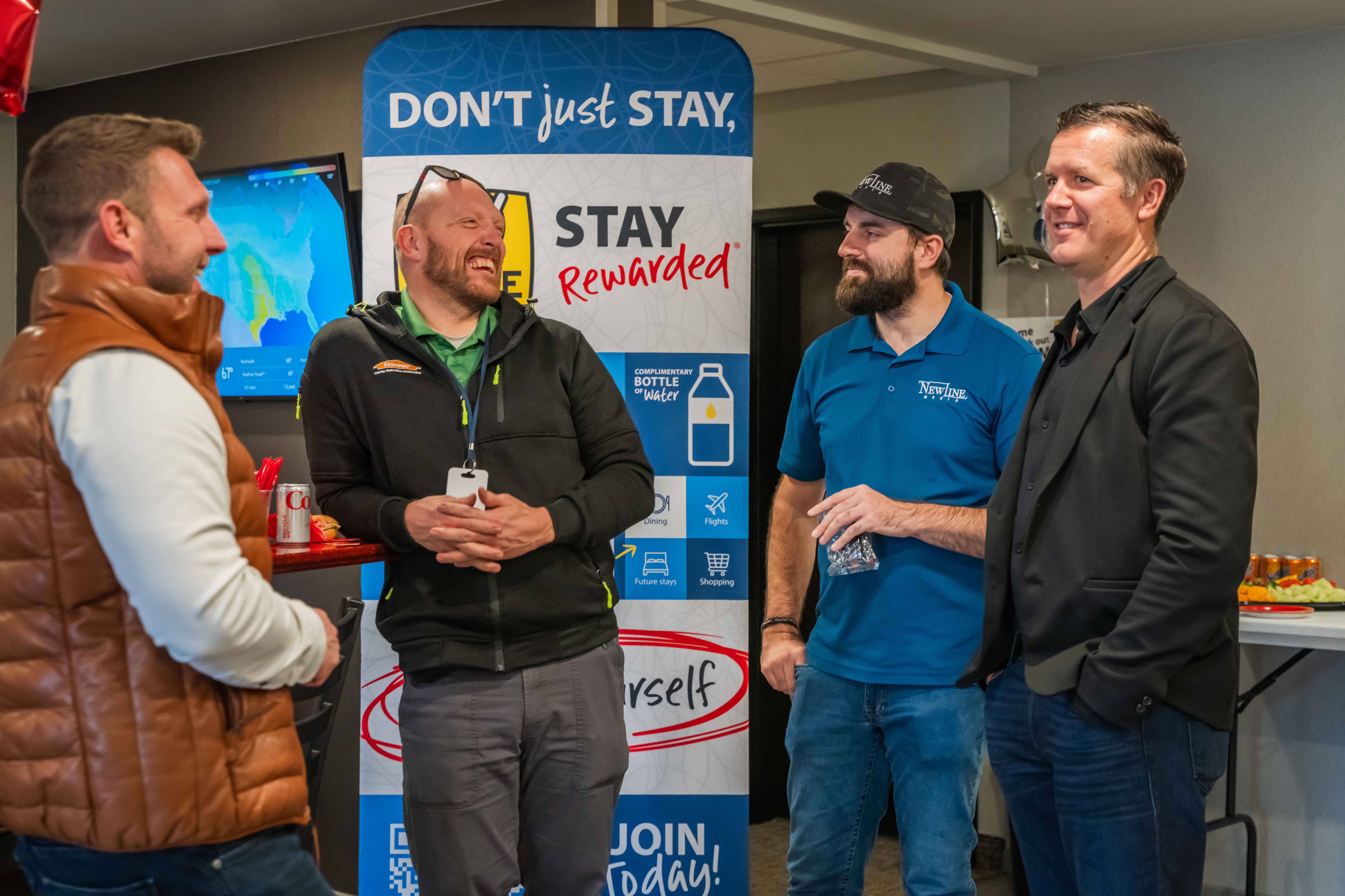 A group of people celebrating a My Place Hotel grand opening