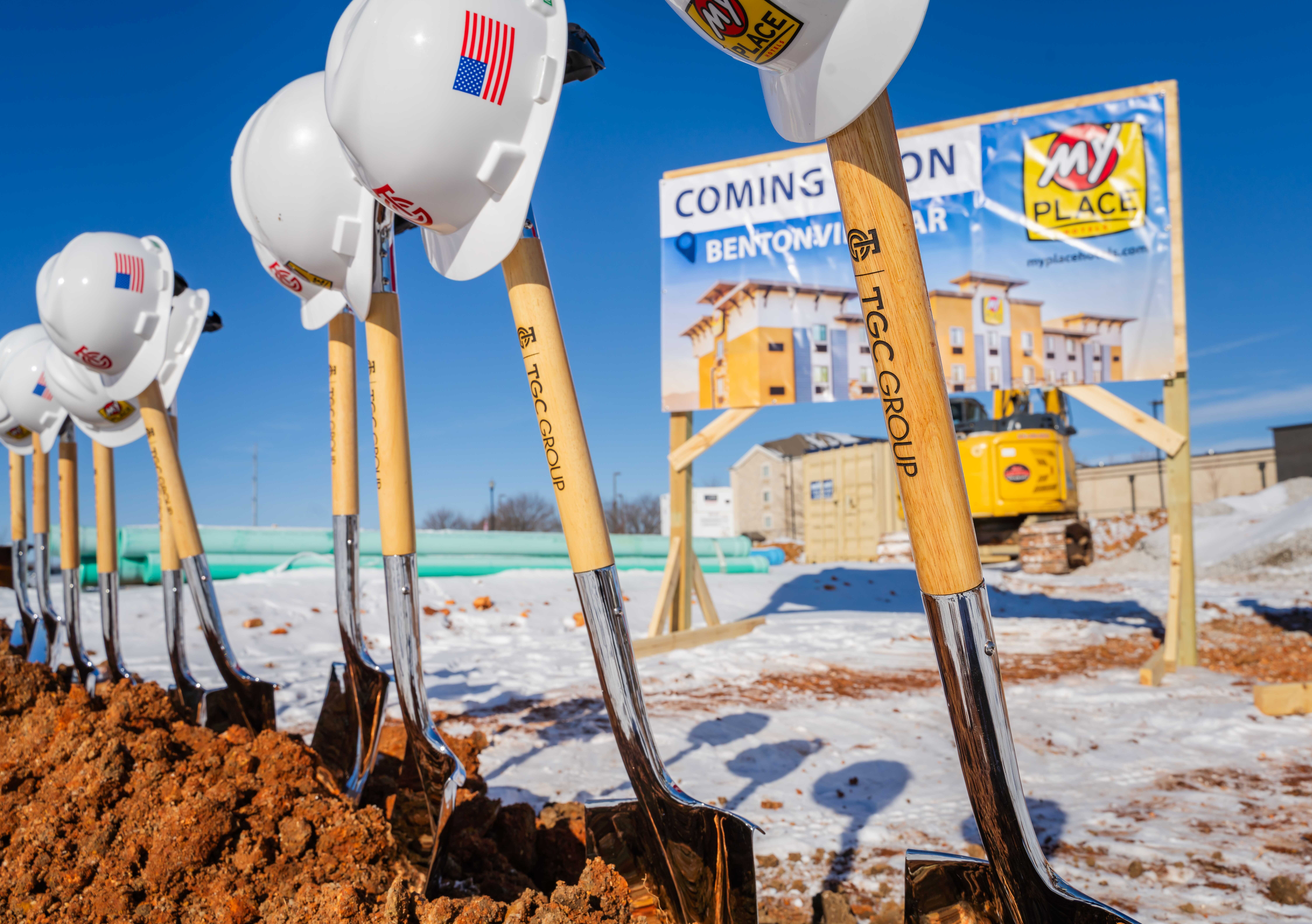 A line of shovels and hard hats set up at a construction site