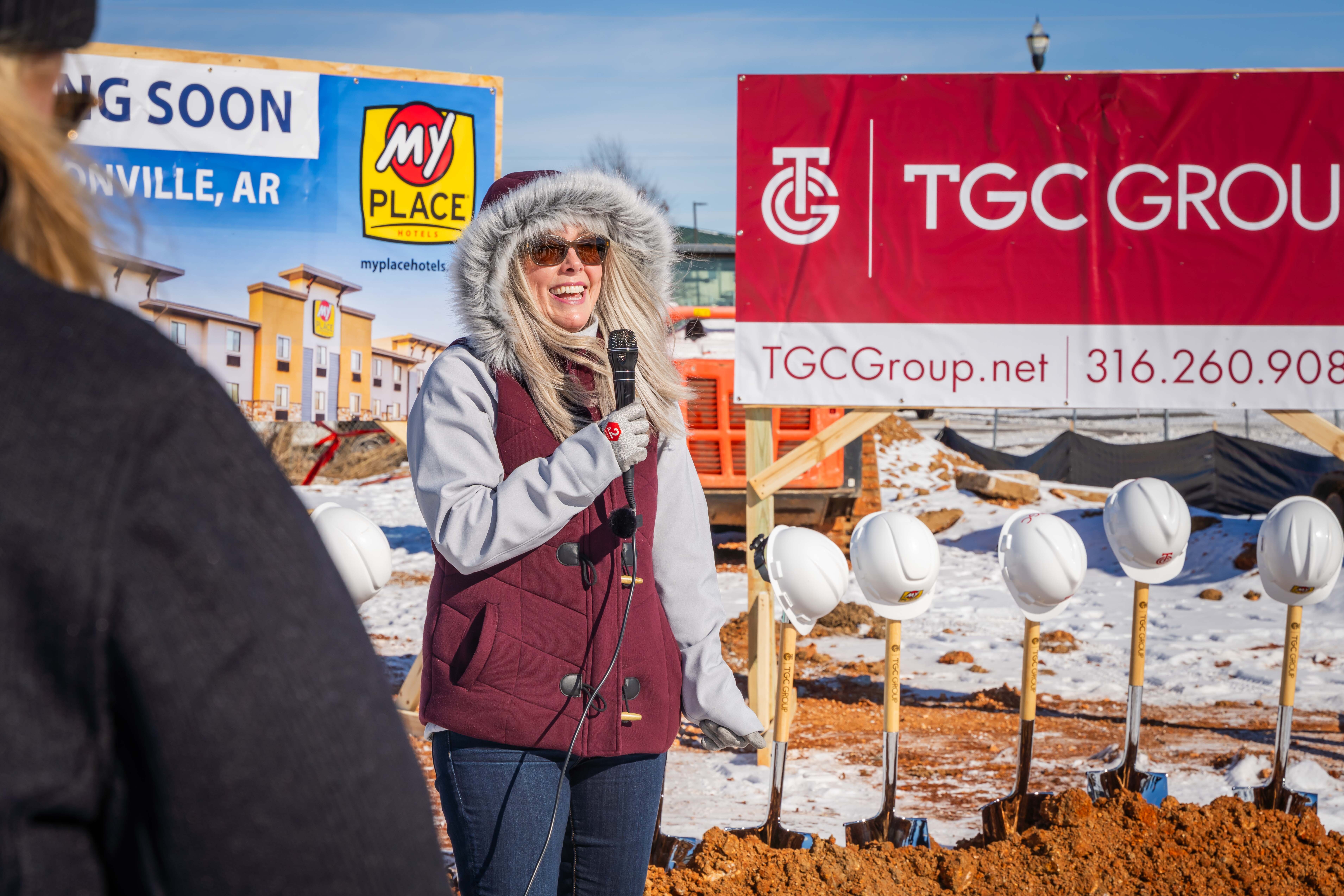 A woman smilling while she speaks at a groundbreaking event