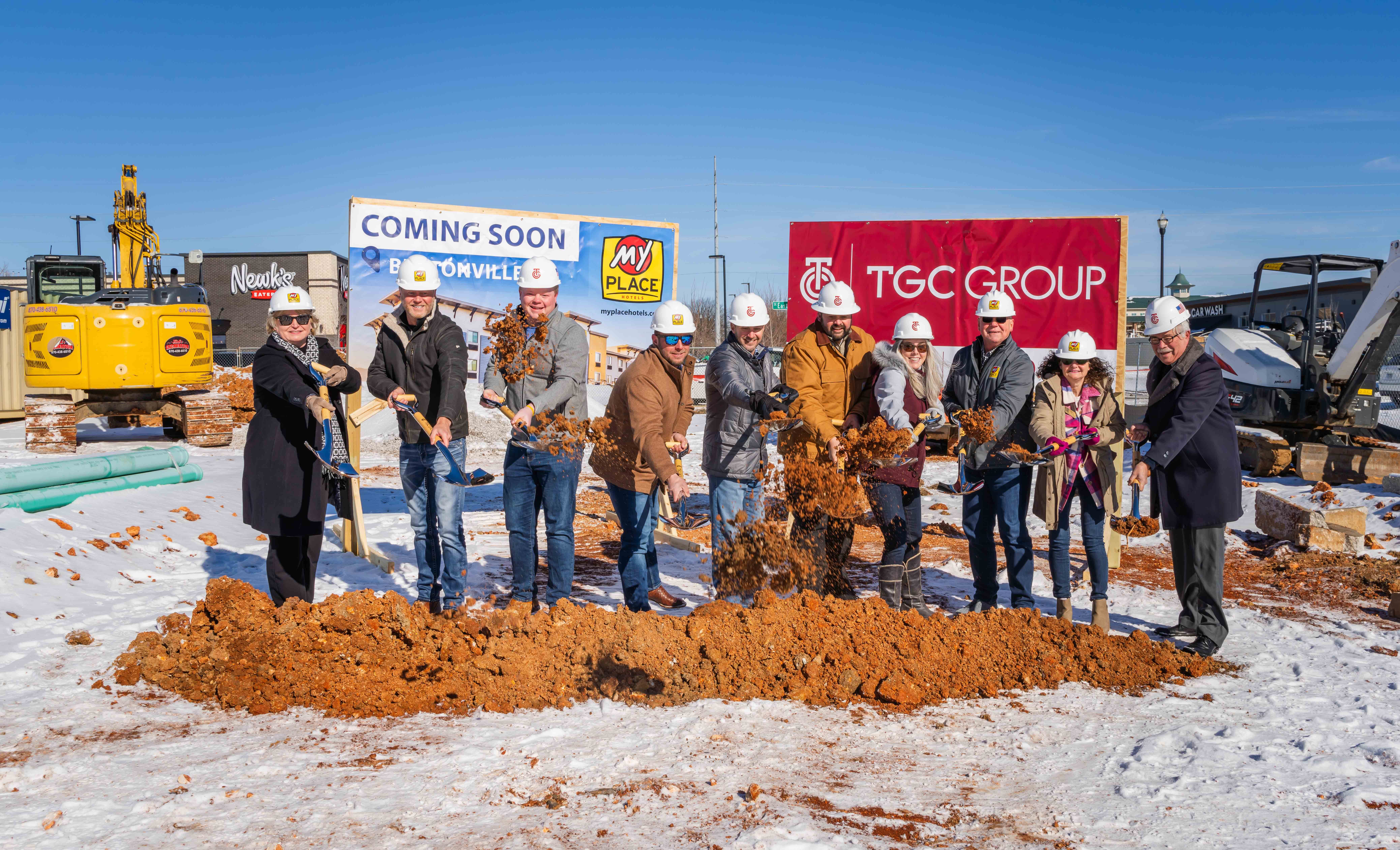 Group of people throwing dirt for a groundbreaking ceremony