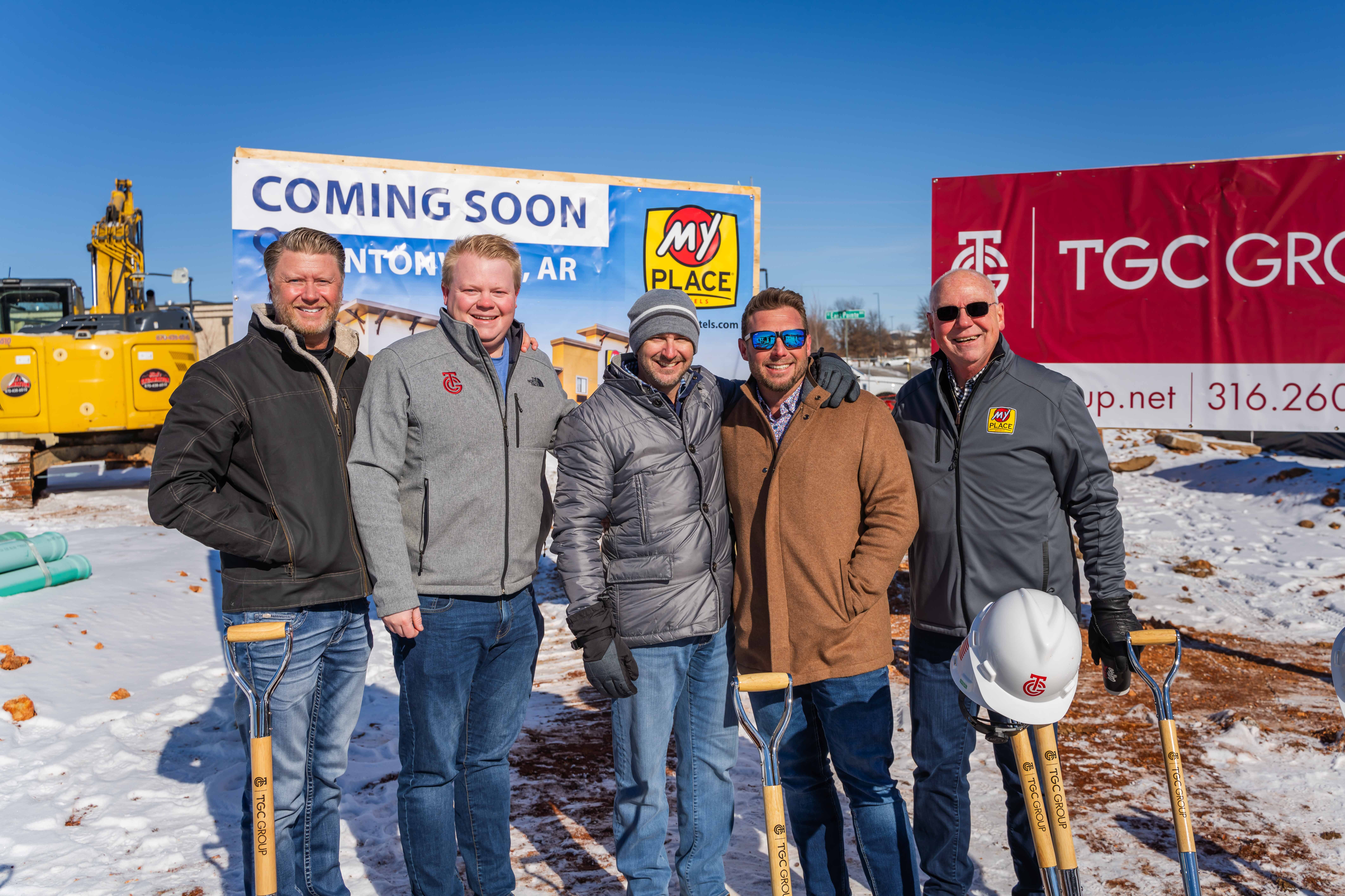 A group of 5 men standing together and smiling for a photo