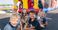 Kids smiling next to a bouncy house.