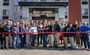 A crowd of people pose outside the hotel entrance ahead of cutting a red ribbon during the grand opening celebration in Nampa, Idaho.