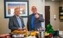 Two men smile while one gives a thumbs up as they talk near the snacks during the grand opening ceremony at the new hotel in Nampa, Idaho.