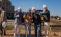 Professionals pose with thumbs up at the groundbreaking in Jonesboro.
