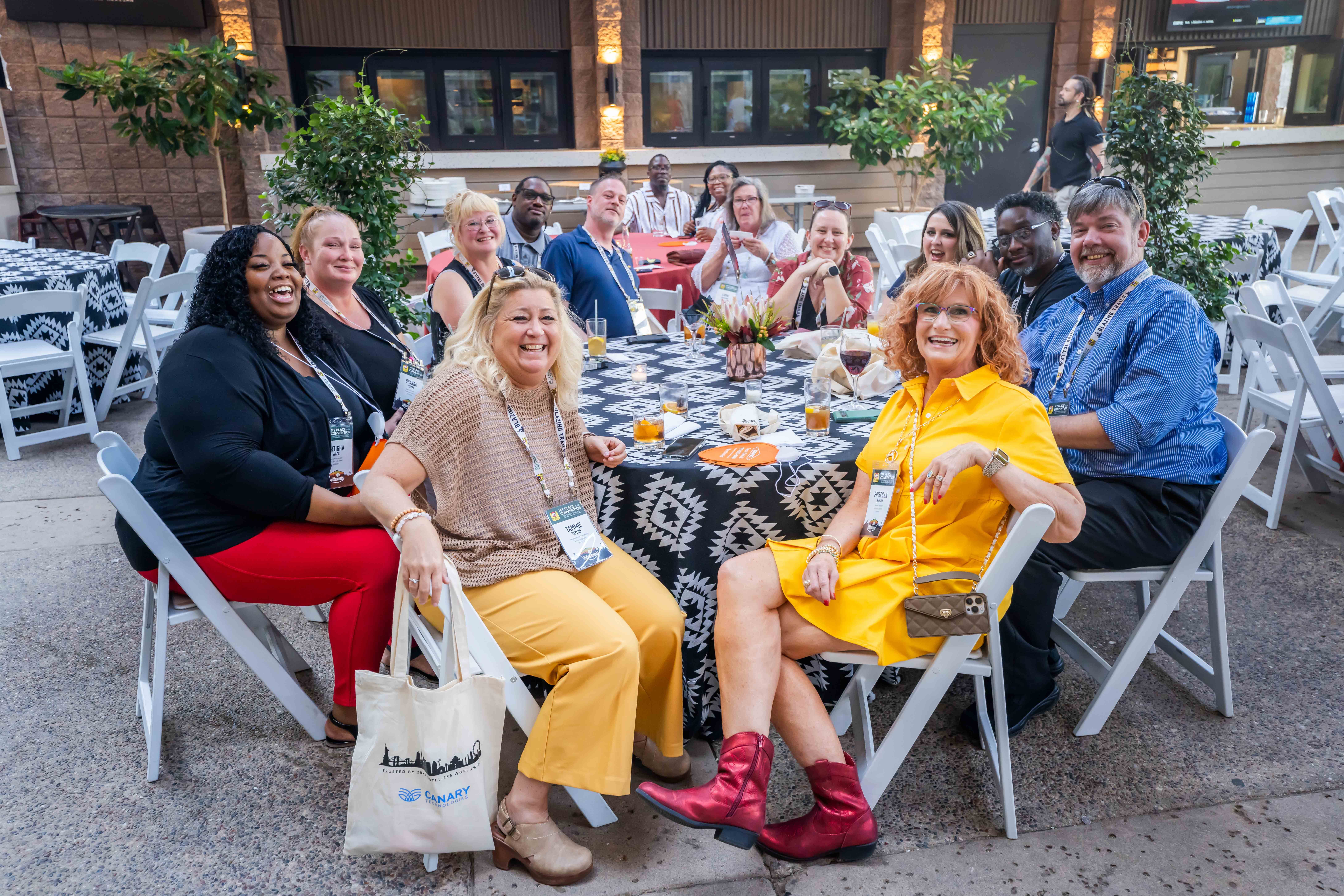 A group of individuals smiling for a photo outdoors at a networking event