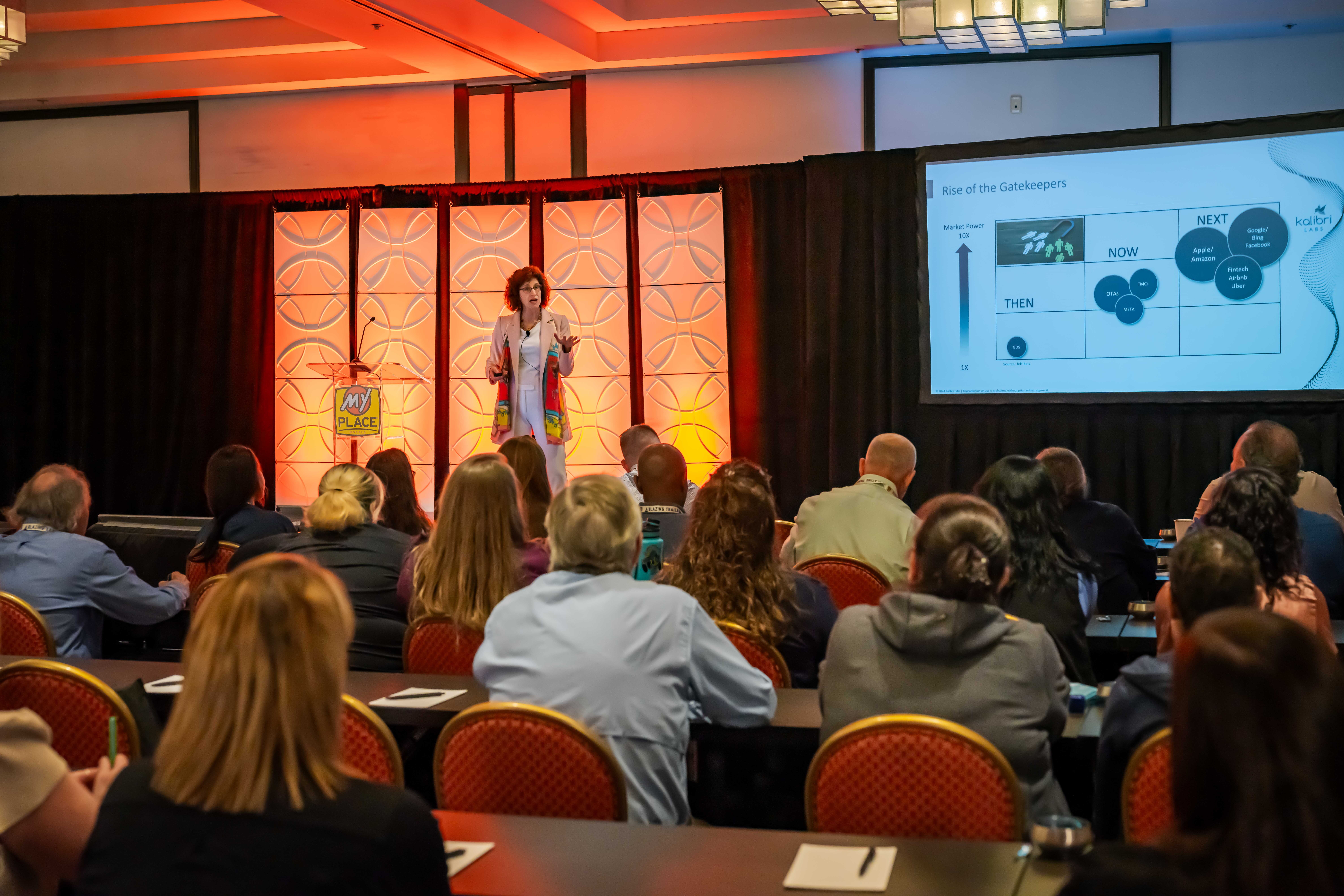 A woman speaking to an audience at a conference