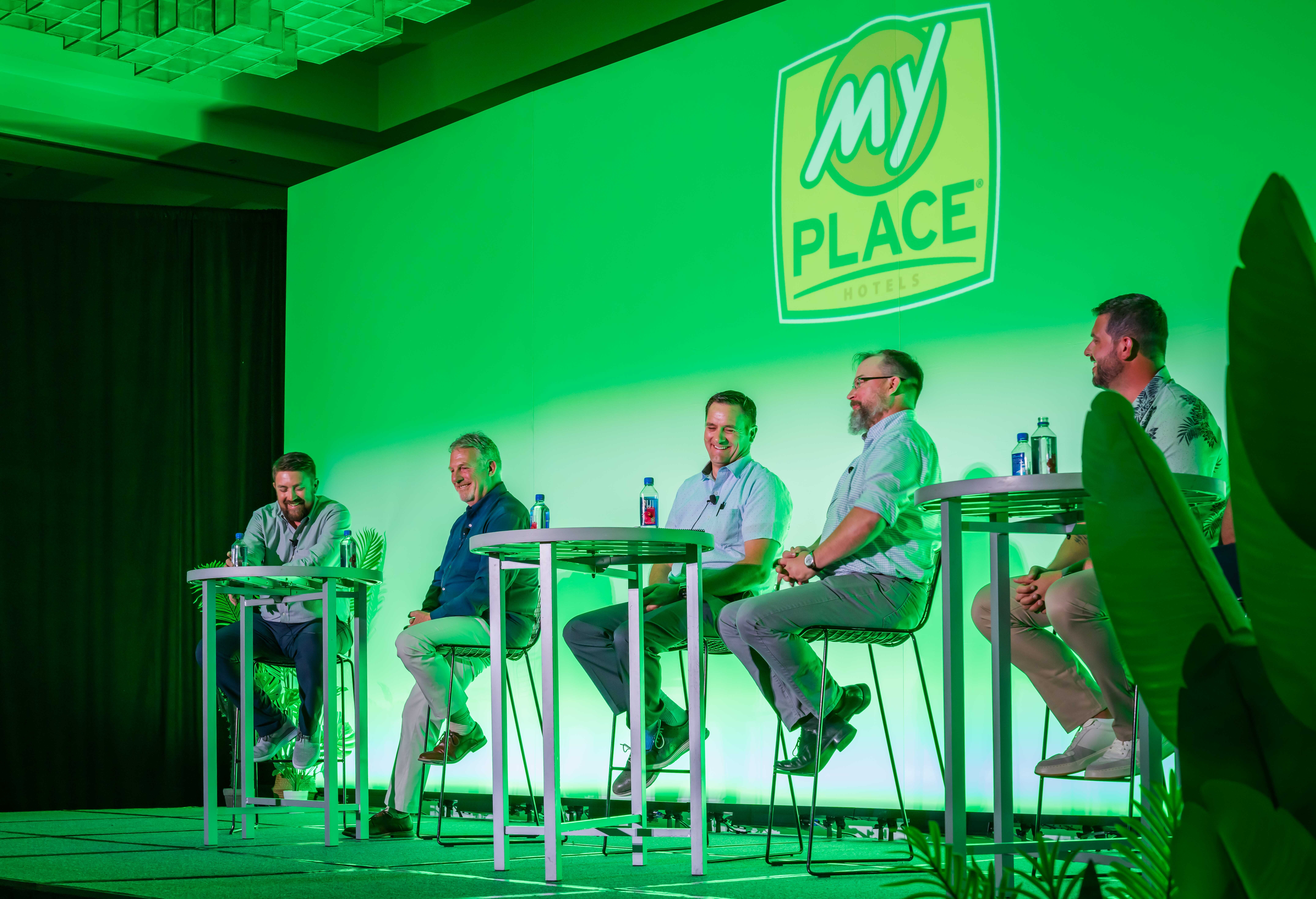 A group of men on stage for a construction panel at a hospitality conference