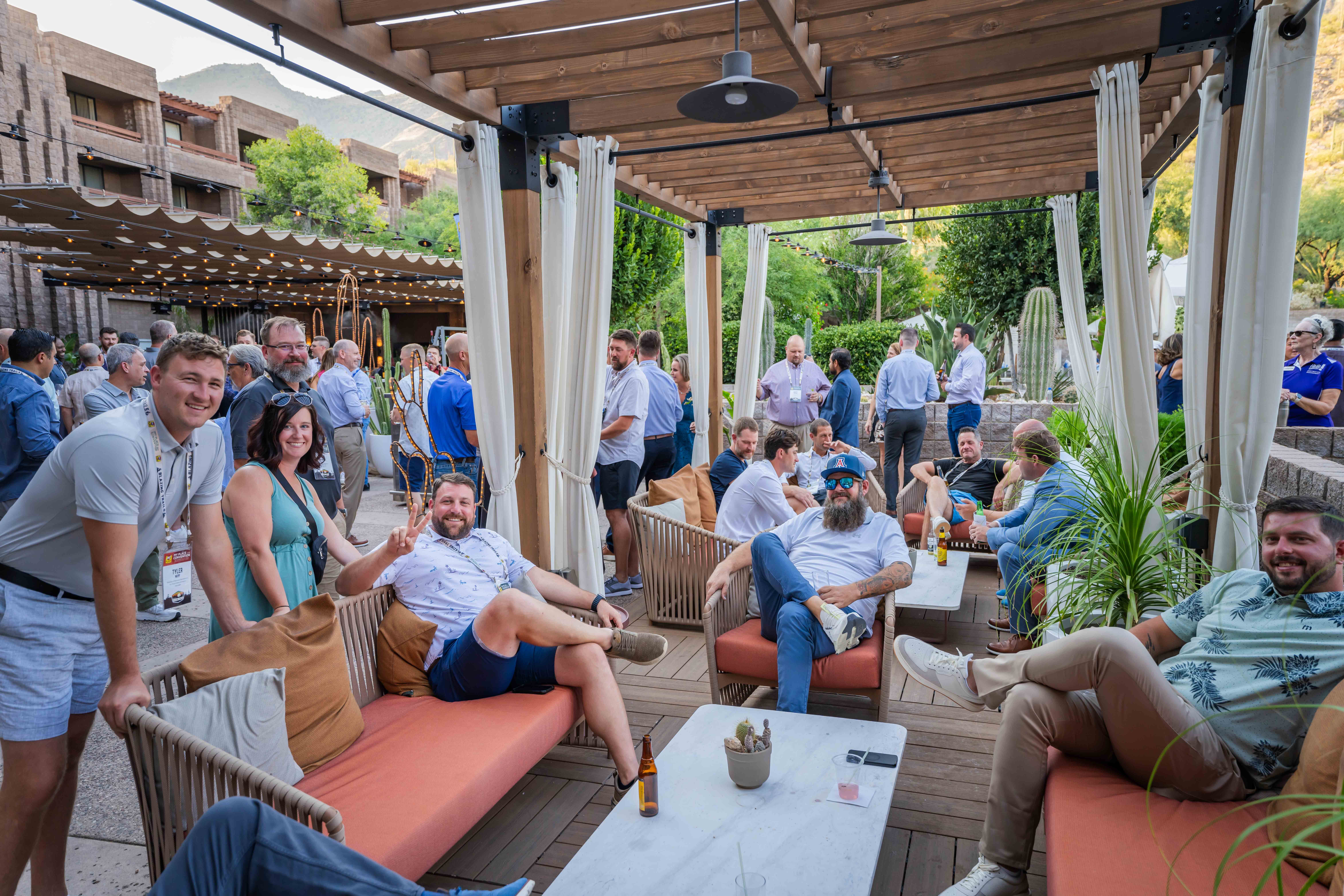 People smiling for the camera at an outdoor cocktail hour