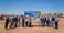 Attendees of the groundbreaking are pictured standing in front of the coming soon sign for the new My Place hotel.
