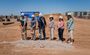 Professionals are pictured holding shovels, scooping up dirt outside at the groundbreaking of Mesa My Place hotel.