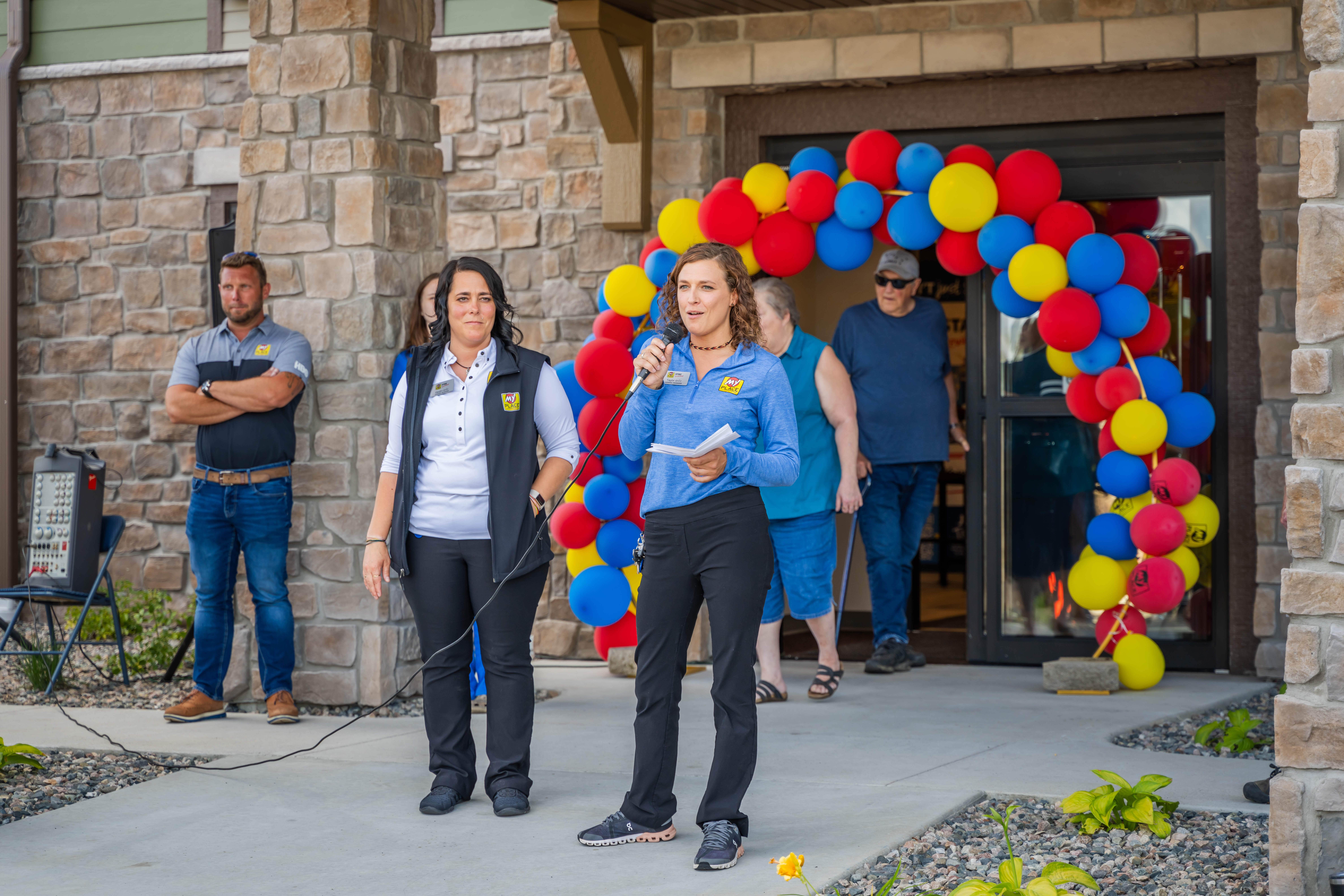 Two women speaking at a grand opening celebration for a new hotel.