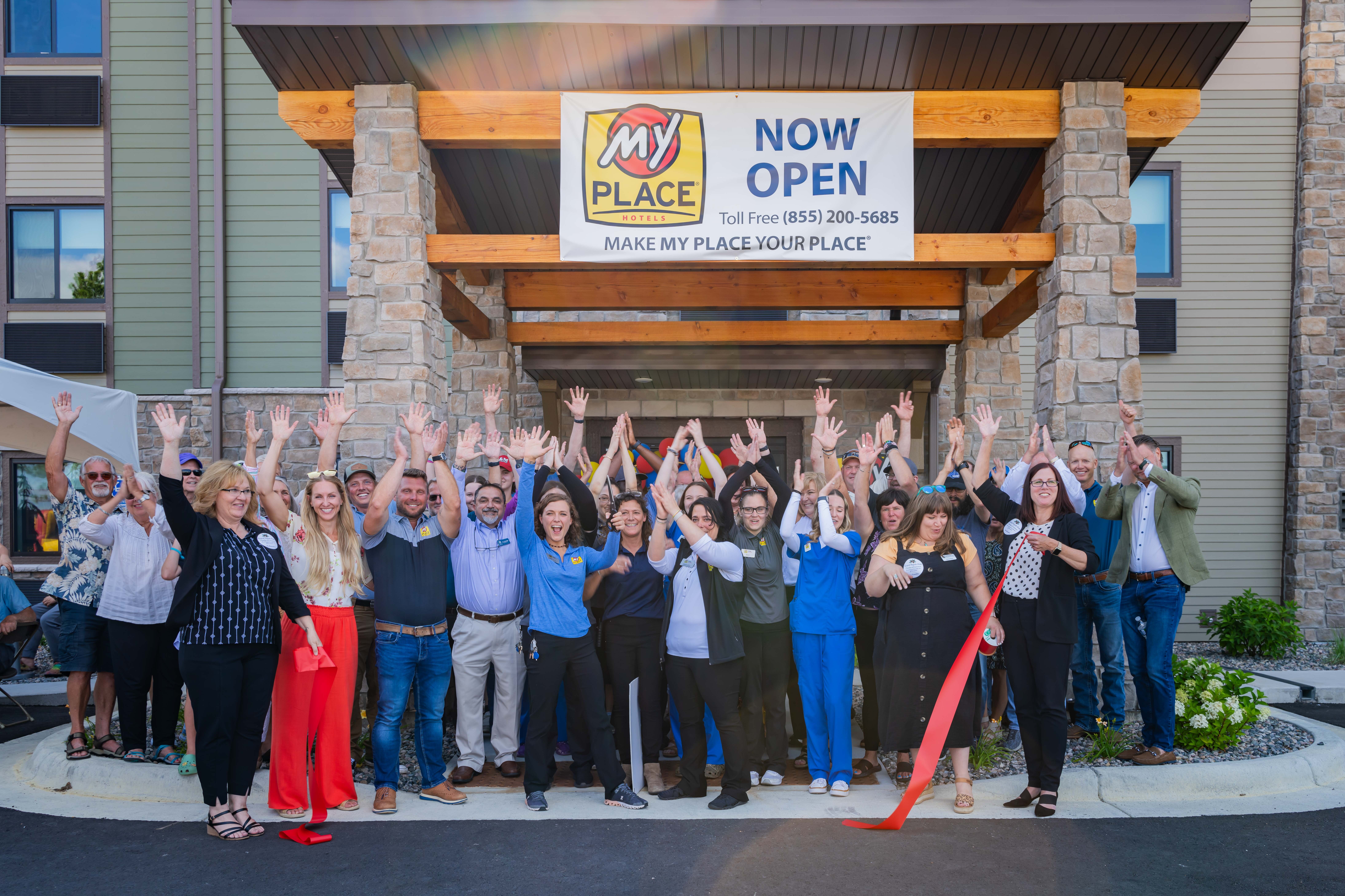 A group of people celebrating after a ribbon cutting ceremony