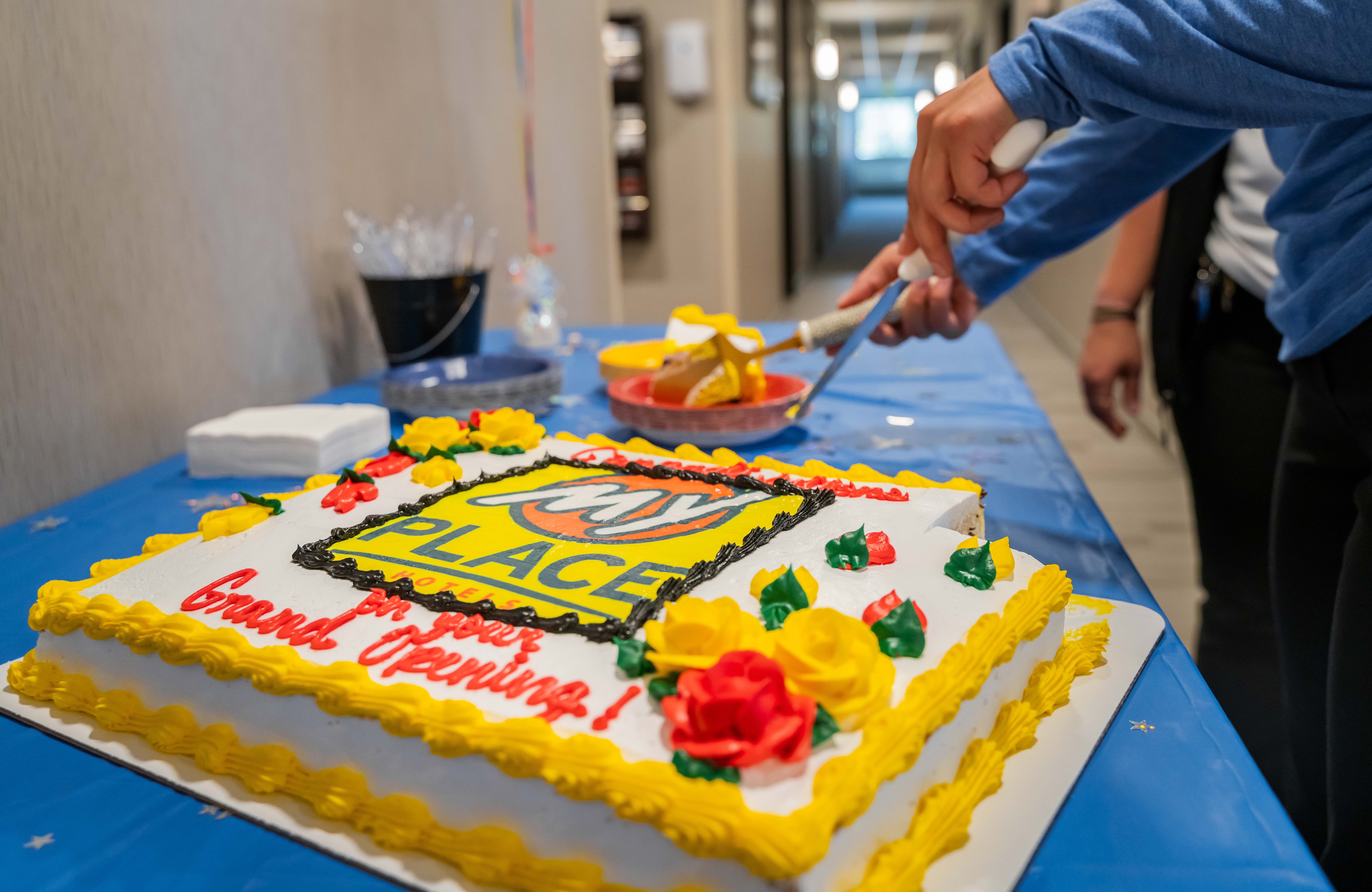 A cake being served at a grand opening celebration