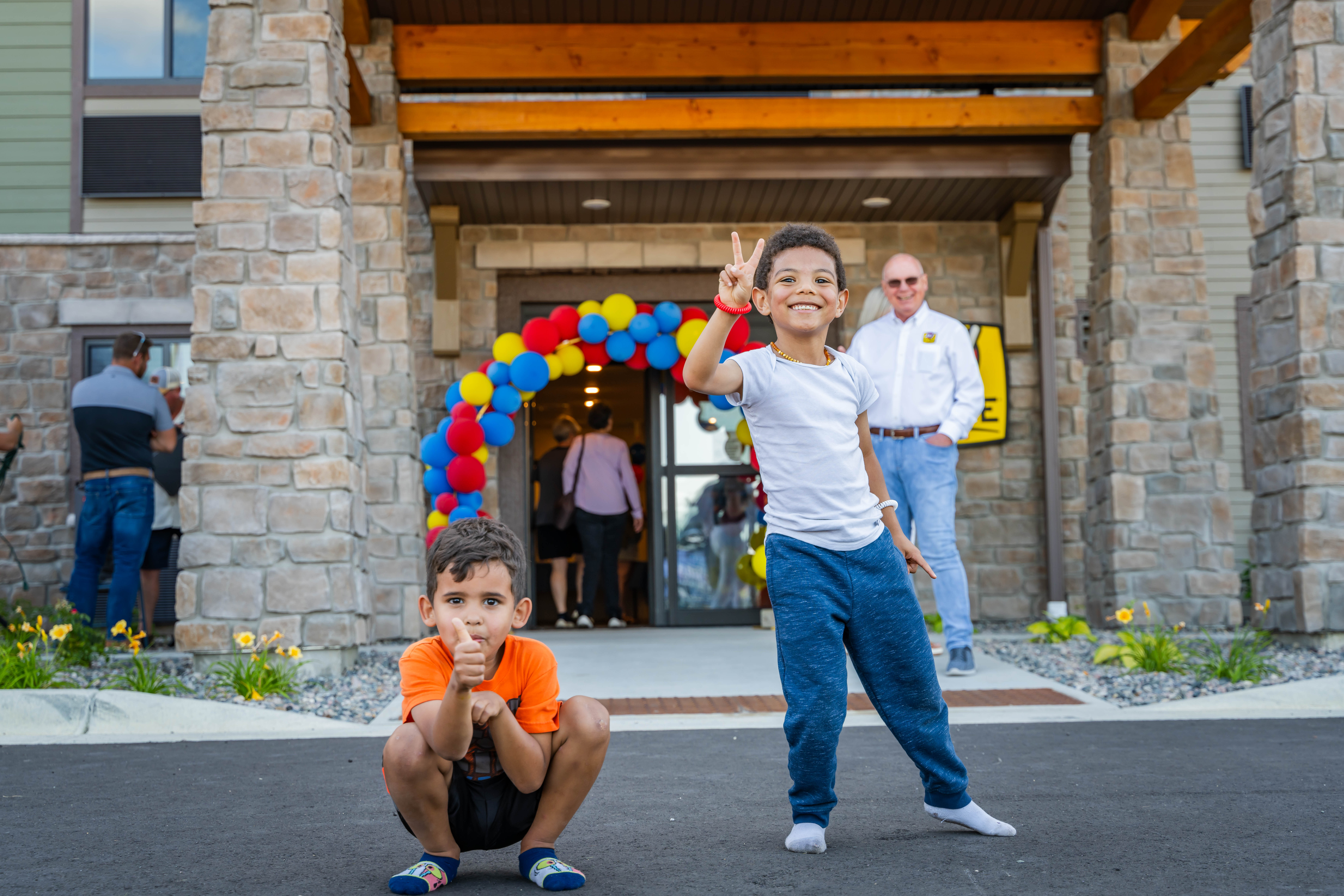 Two kids posing and smiling outside of a hotel