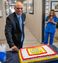 A man is pictured smiling in front of a cake with the My Place hotels logo.