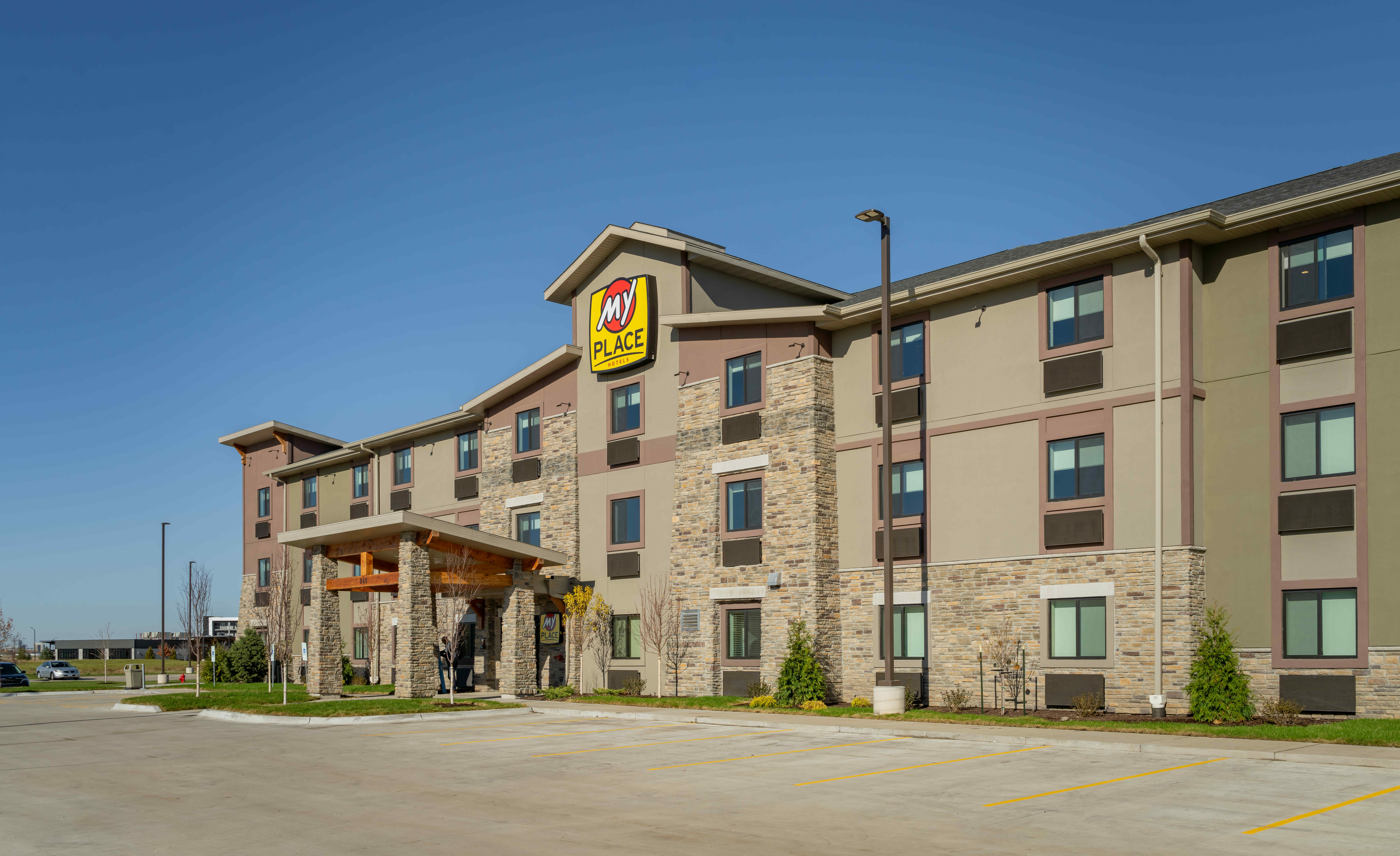 A wide shot showing the hotel's exterior and parking lot ahead of the grand opening celebration.