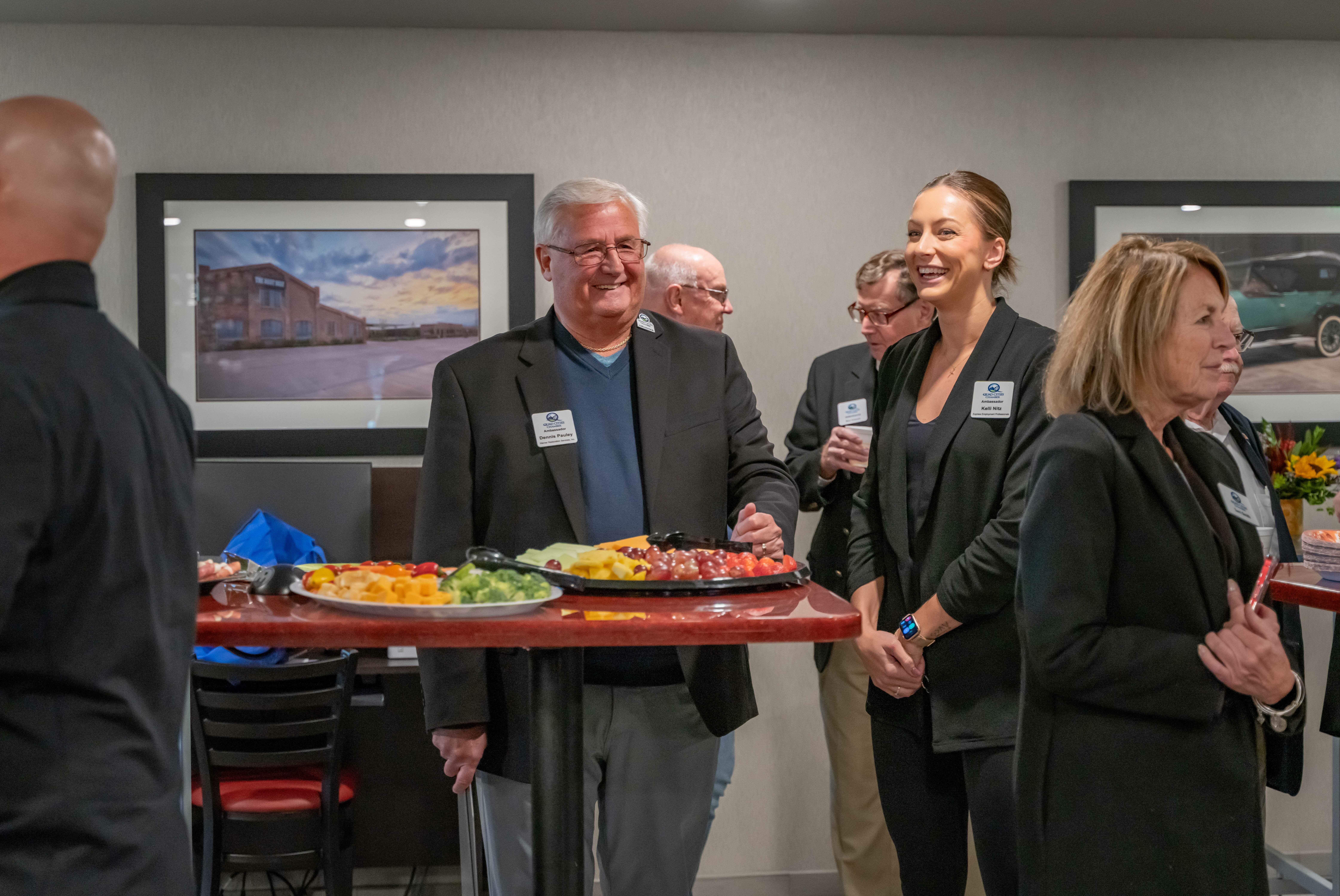 A small group of people congregate around snacks during the grand opening ceremony inside the hotel's lobby.