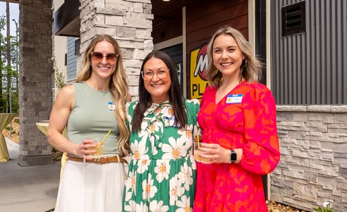 Three guests pose for a picture outside of the new hotel.