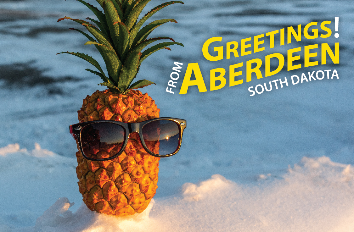 A postcard featuring Pineapple Pete sitting atop a snow bank with "Greetings from Aberdeen, South Dakota" in the top right corner.