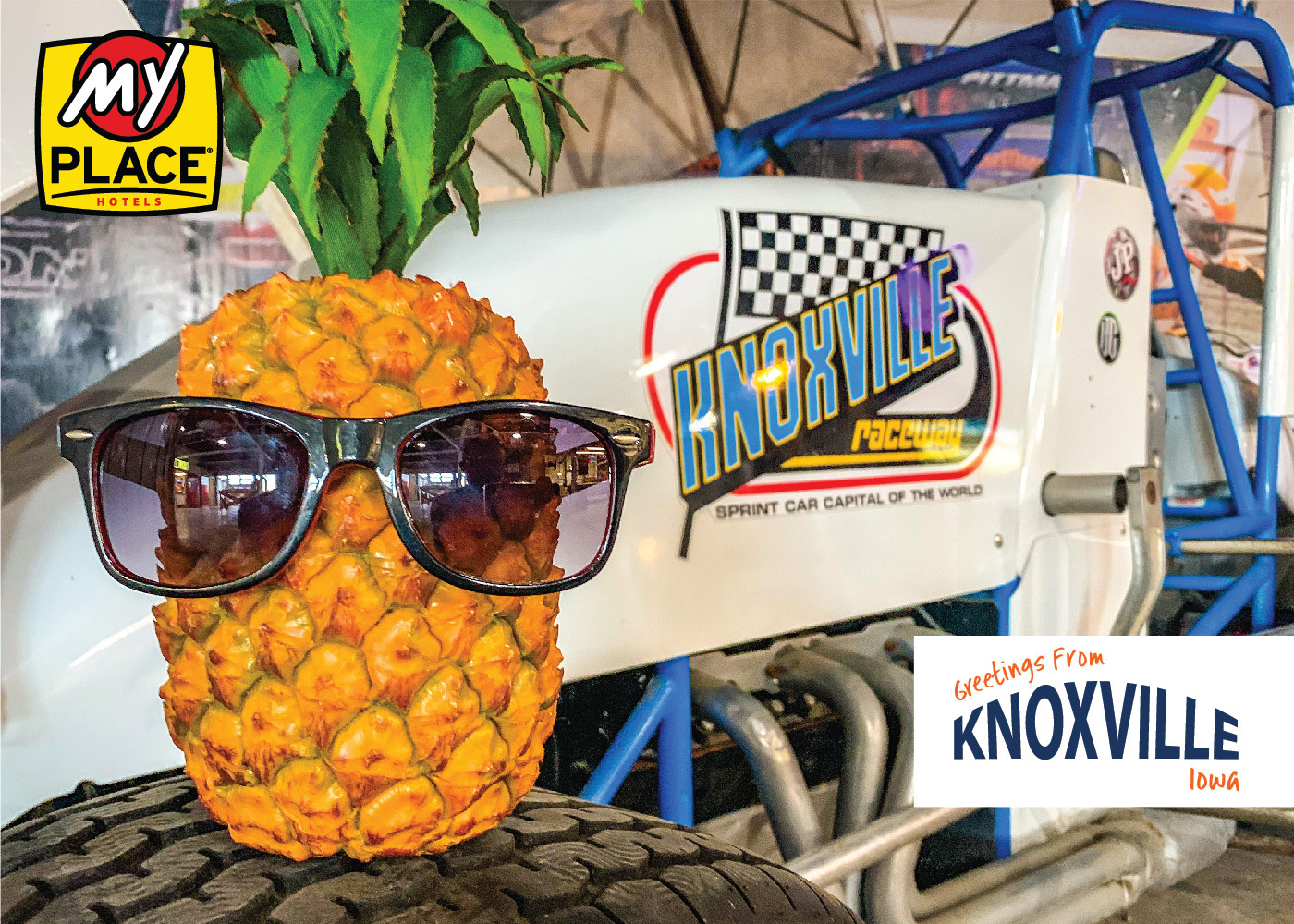 A postcard featuring Pineapple Pete sitting on a tire with a racecar in the background with "Greetings From Knoxville, Iowa" logo in the bottom right corner.