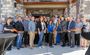 Attendees are pictured standing outside of the new hotel, watching as the ribbon is cut for the grand opening.