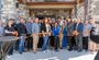 Attendees are pictured standing outside of the new hotel, watching as the ribbon is cut for the grand opening.
