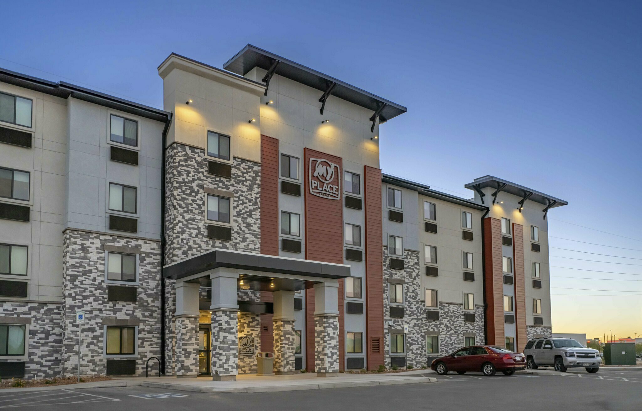 Exterior of Tucson, AZ hotel at dusk, with a blue sky and exterior hotel lighting.