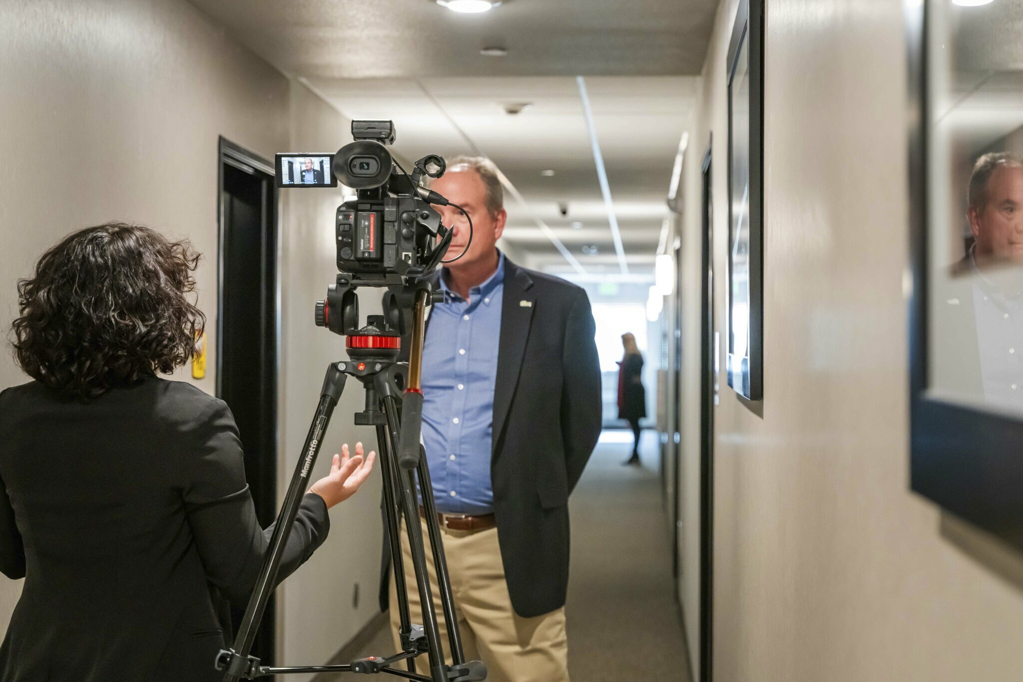 A reporter conducts a video interview of a man in a hallway inside the brand new hotel in Nampa, Idaho.