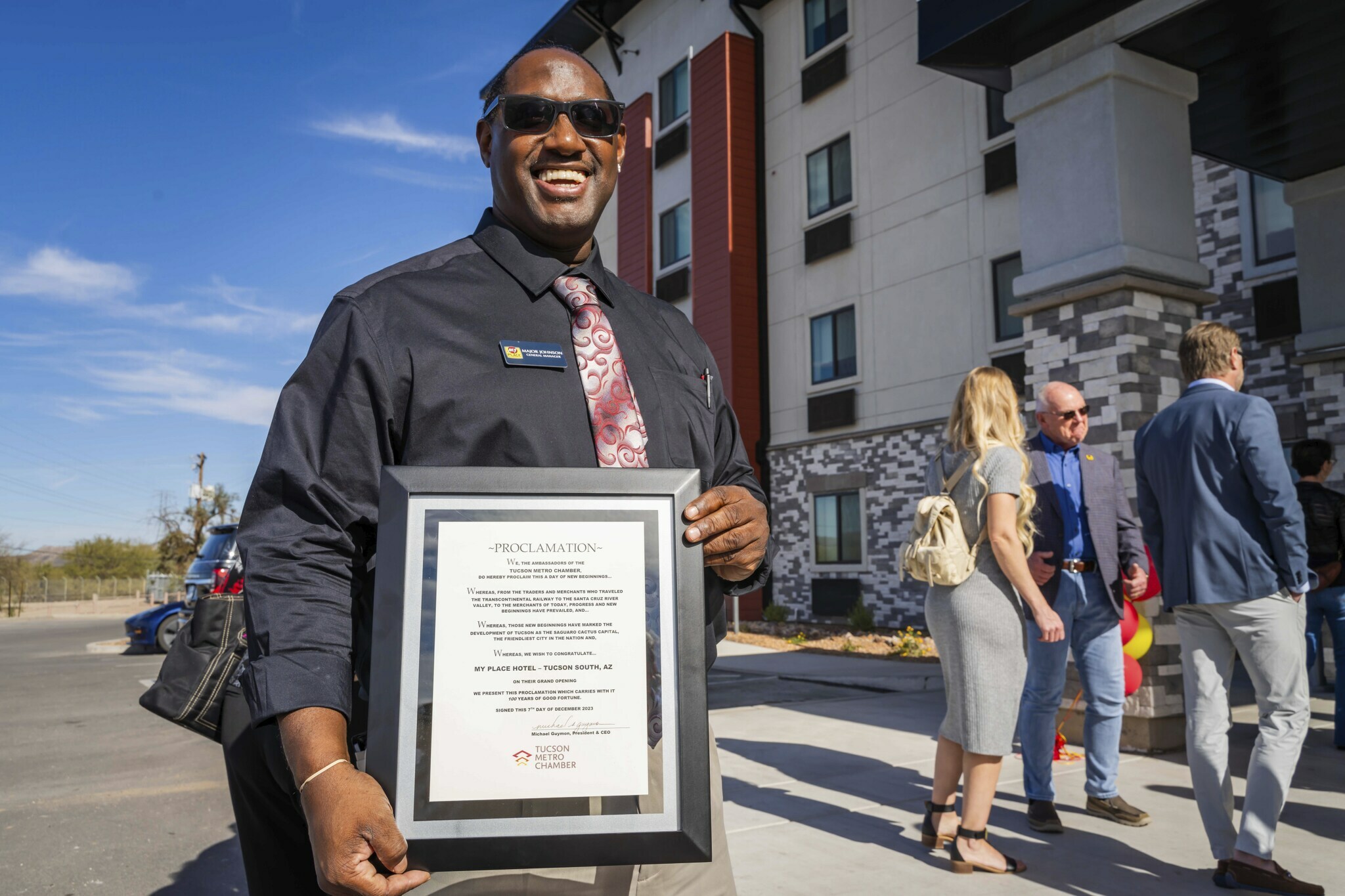 The Nampa, Idaho general manager holds a proclamation outside the hotel during the grand opening ceremony.
