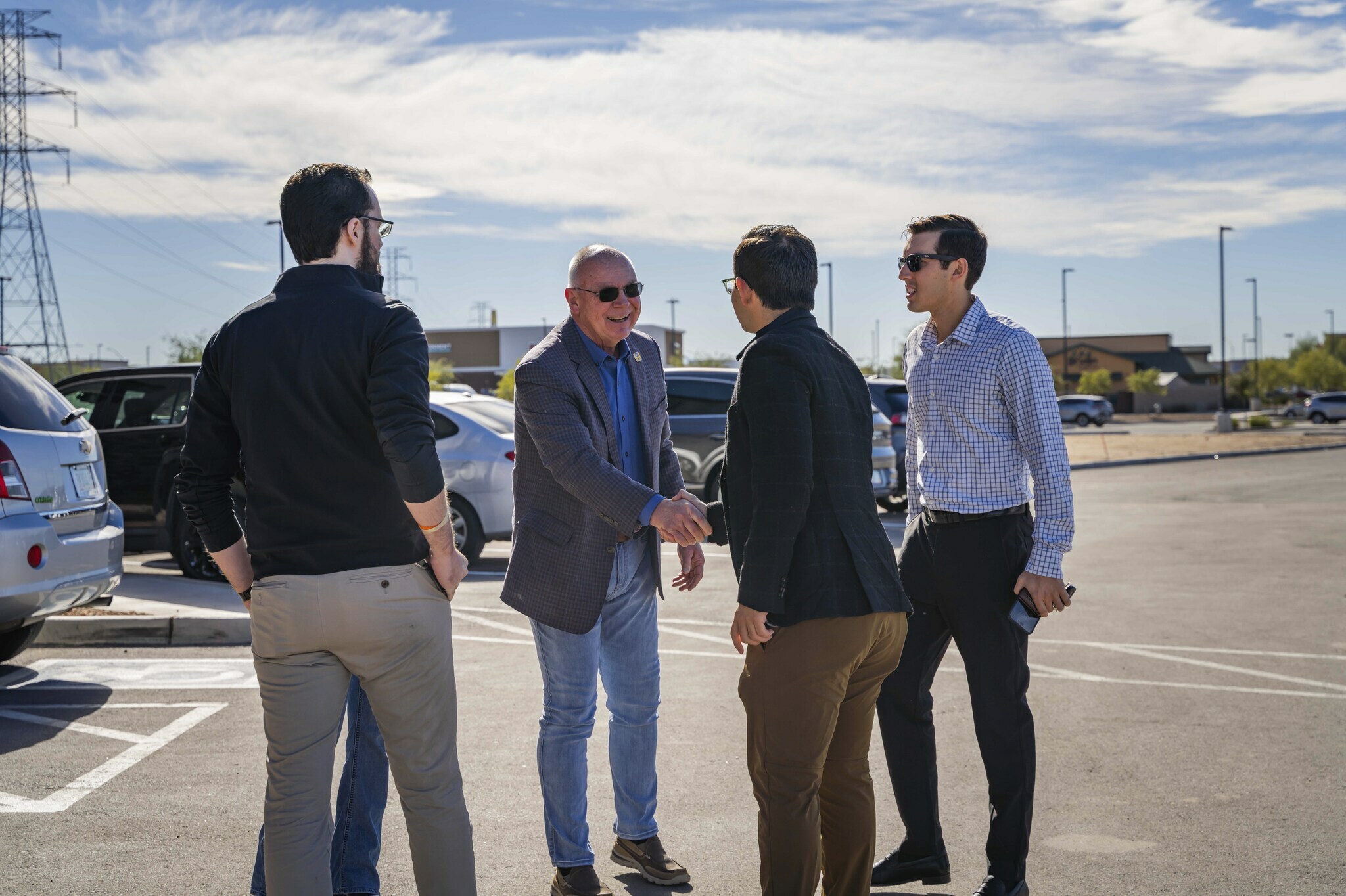 Five men smile and talk outside the new hotel in Nampa, Idaho during the grand opening celebration.