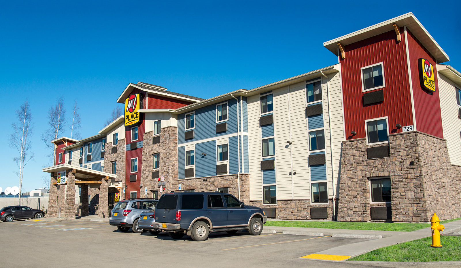 Exterior view of My Place Hotel with sidewalk ramp.