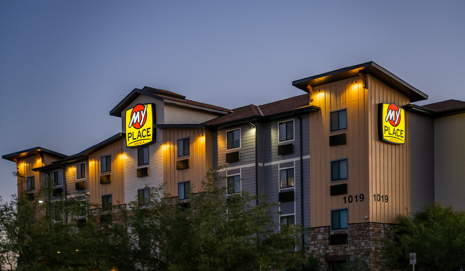 Exterior of My Place Hotel-Buckeye, AZ with logo shining bright in the night.