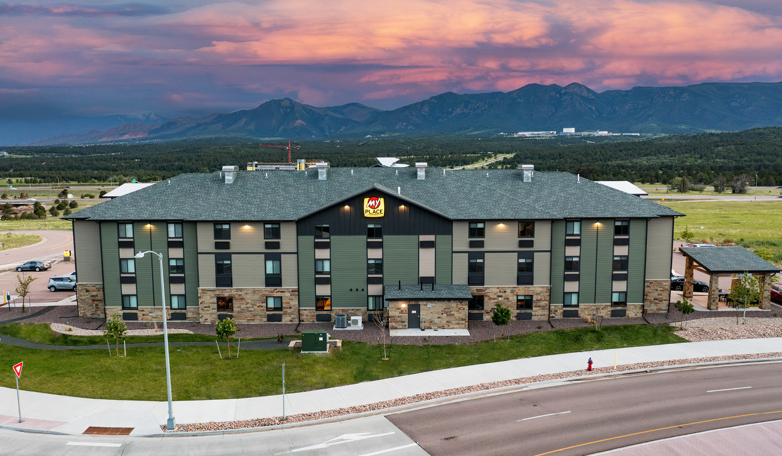 My Place Hotel-Colorado Springs, CO with mountains and vibrant sunset in the sky.