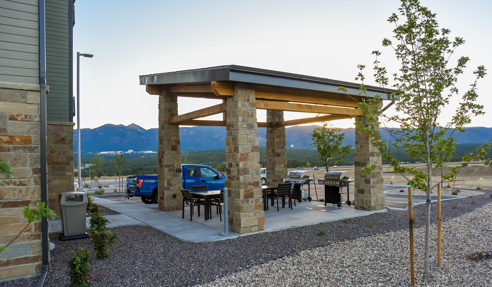 Grilling pavilion with two grills, outdoor chairs and a relaxing mount view.