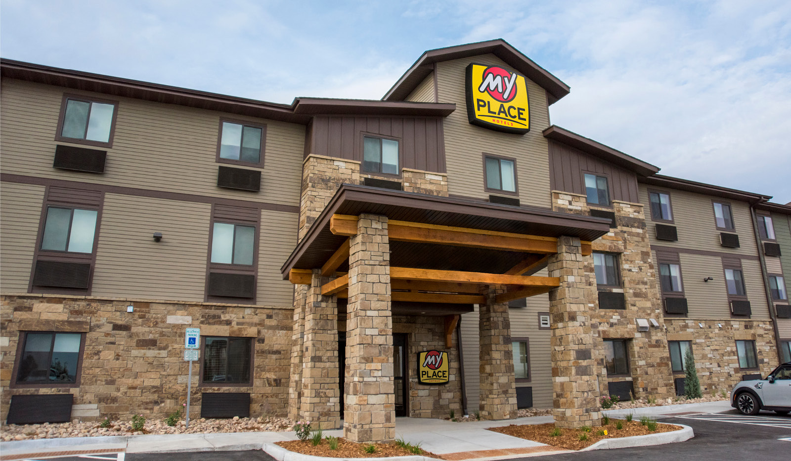 Accessible main entrance to hotel with accessible parking space.
