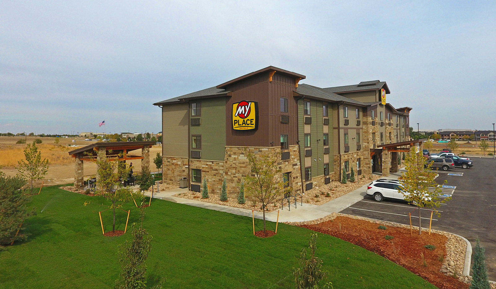 Side of property with grilling pavilion in the back accessible by walkway or greenspace.