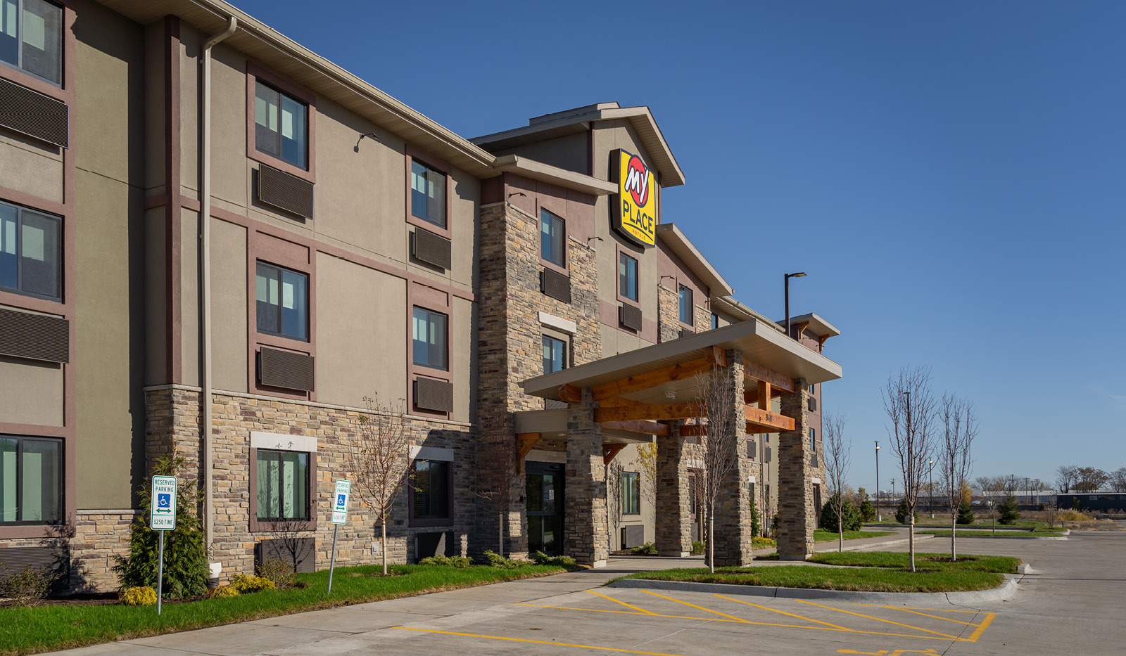 Exterior of My Place Hotel-East Moline, IL under a clear blue sky.