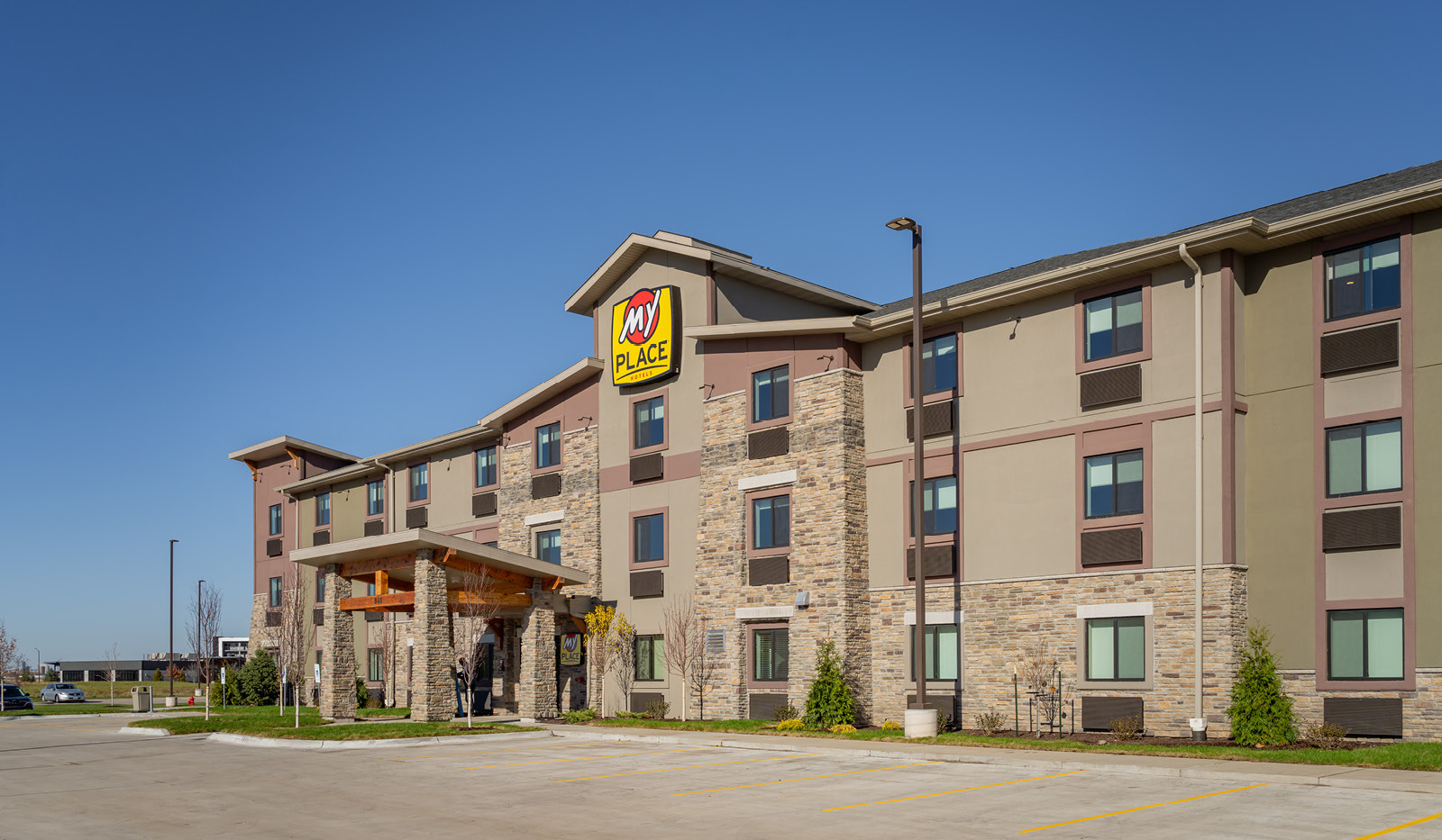 Exterior of My Place Hotel-East Moline, IL under a clear blue sky.