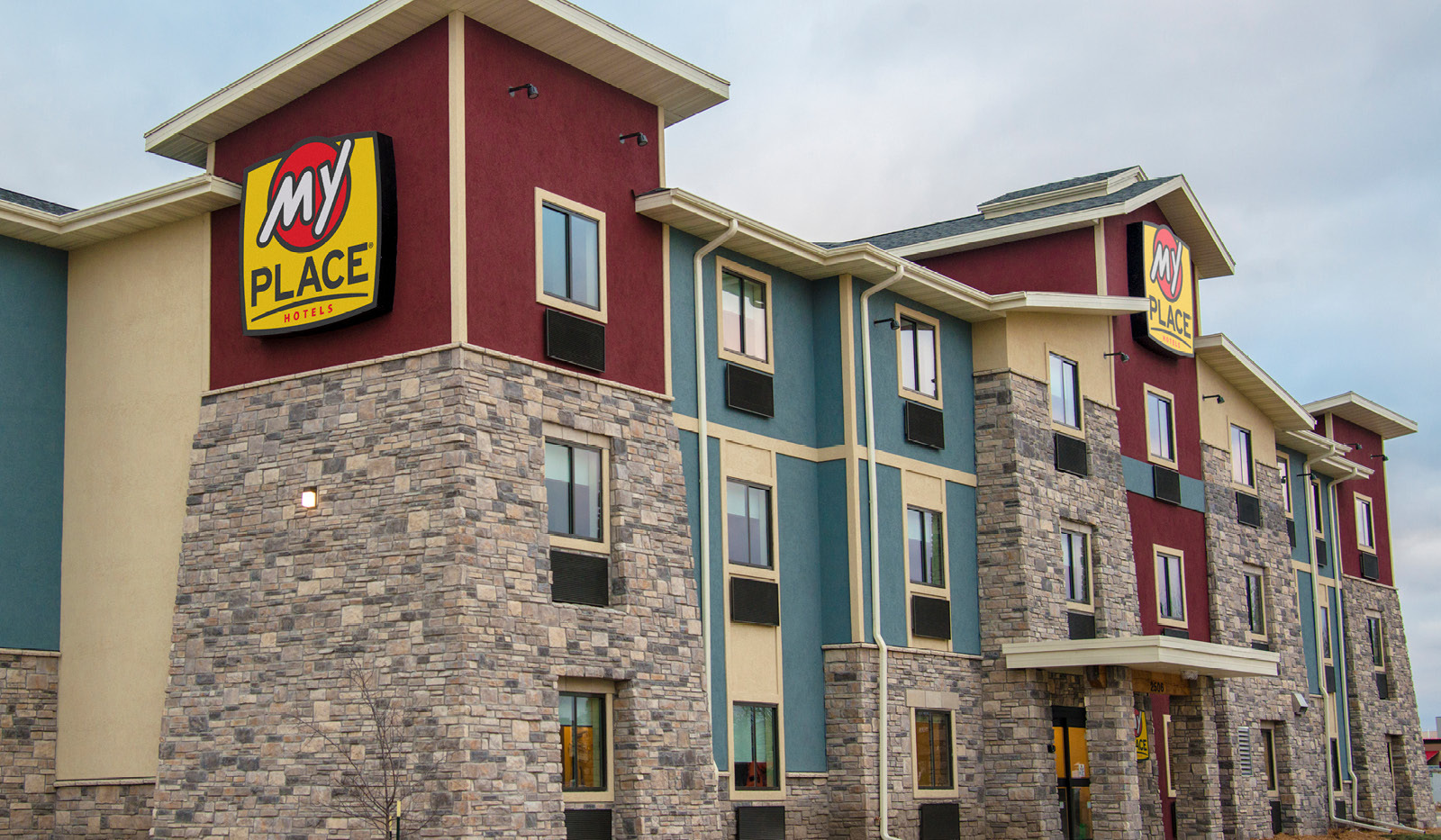 Exterior of My Place Hotel-Ankeny, IA under a cloudy sky.