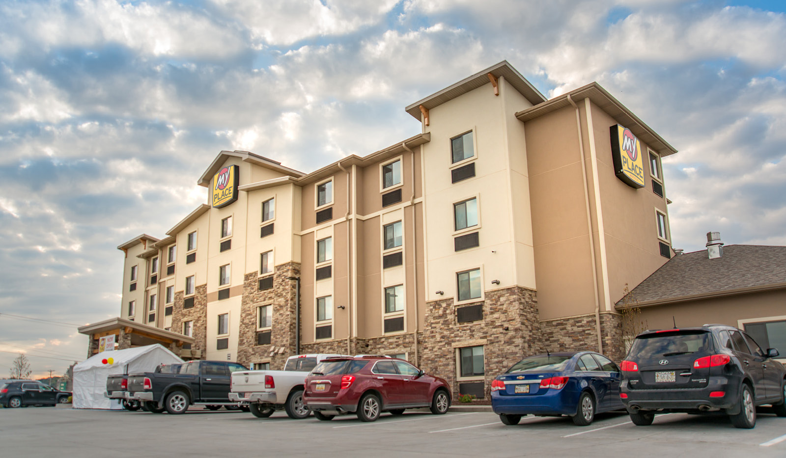 Exterior of My Place Hotel-Council Bluffs, IA with cars in the parking lot.