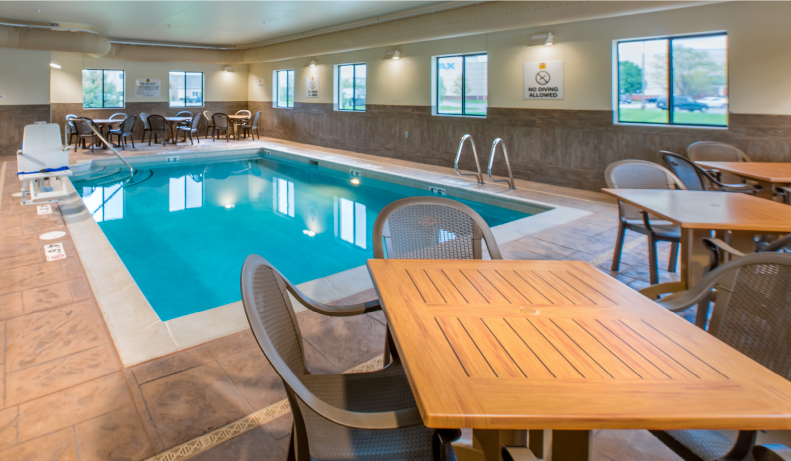 Exterior of My Place Hotel-Council Bluffs, IA's pool area with tables and chairs.