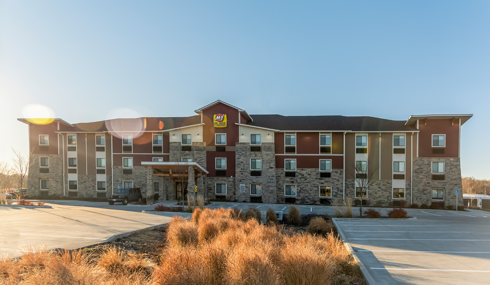Exterior of My Place Hotel-Overland Park, KS under a clear blue sky.