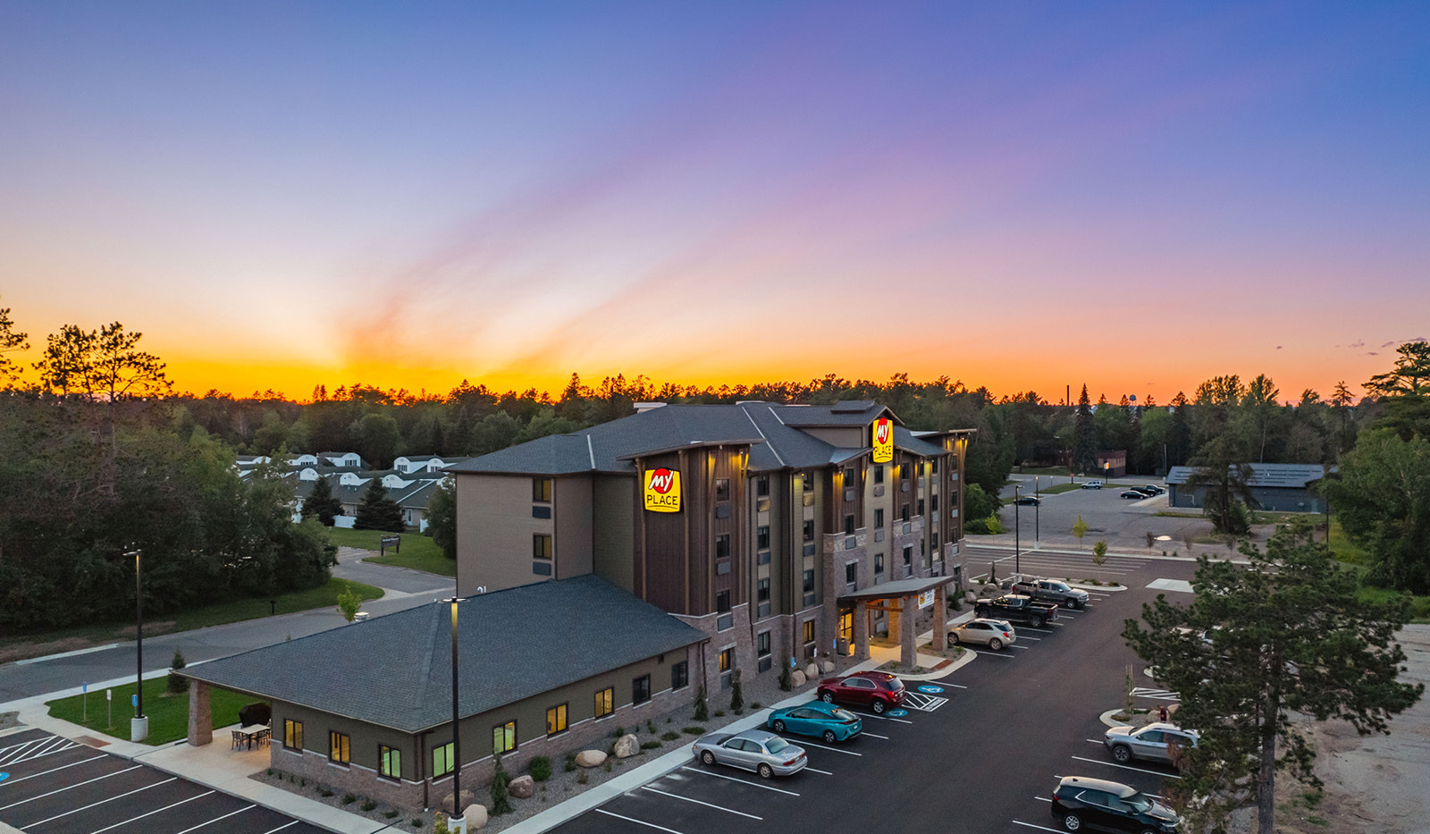 View of the property at sunset with a vibrant orange, violet, pink and blue sky.