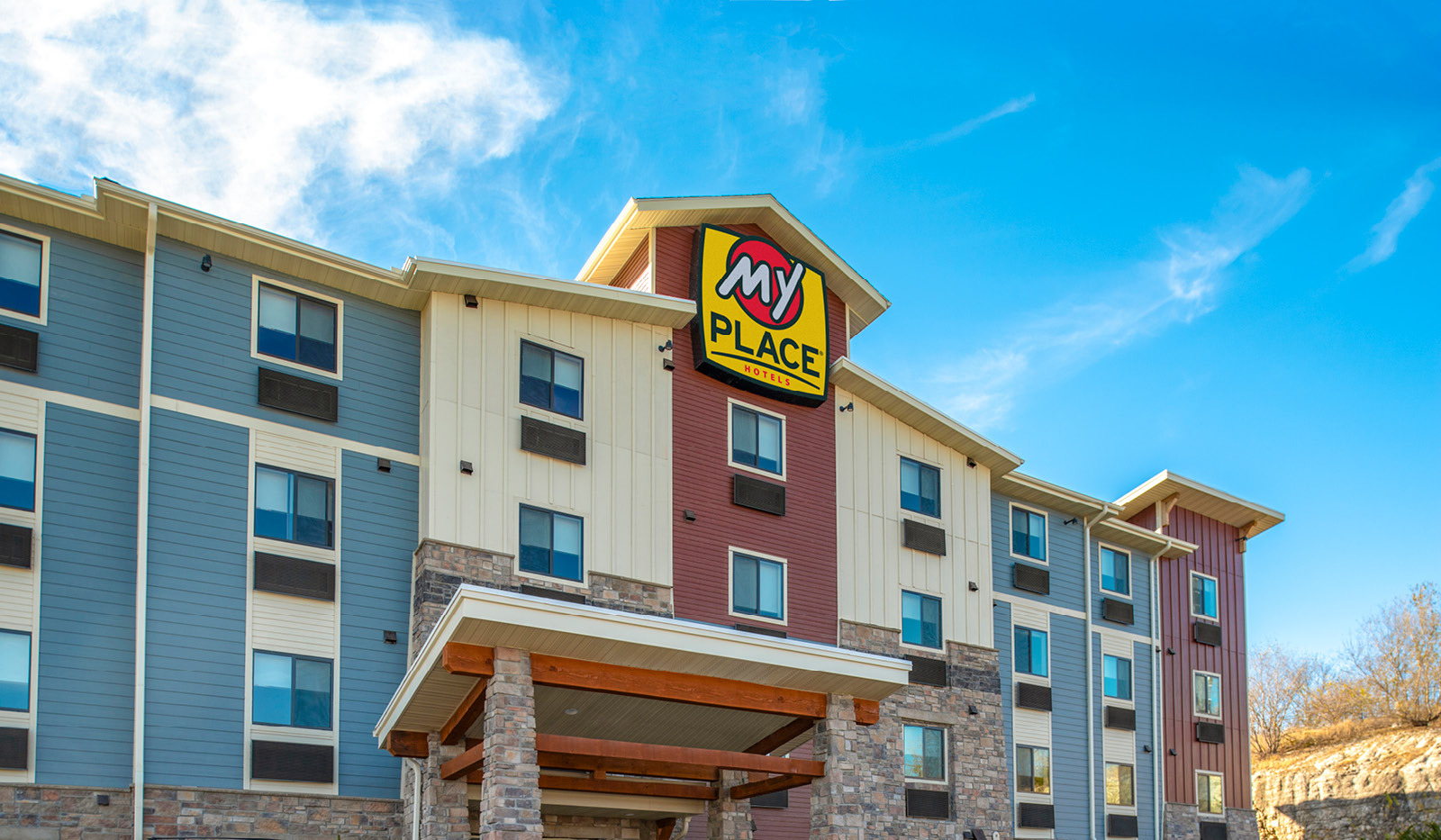 Exterior of My Place Hotel-Independence, MO under a blue, cloudy sky.