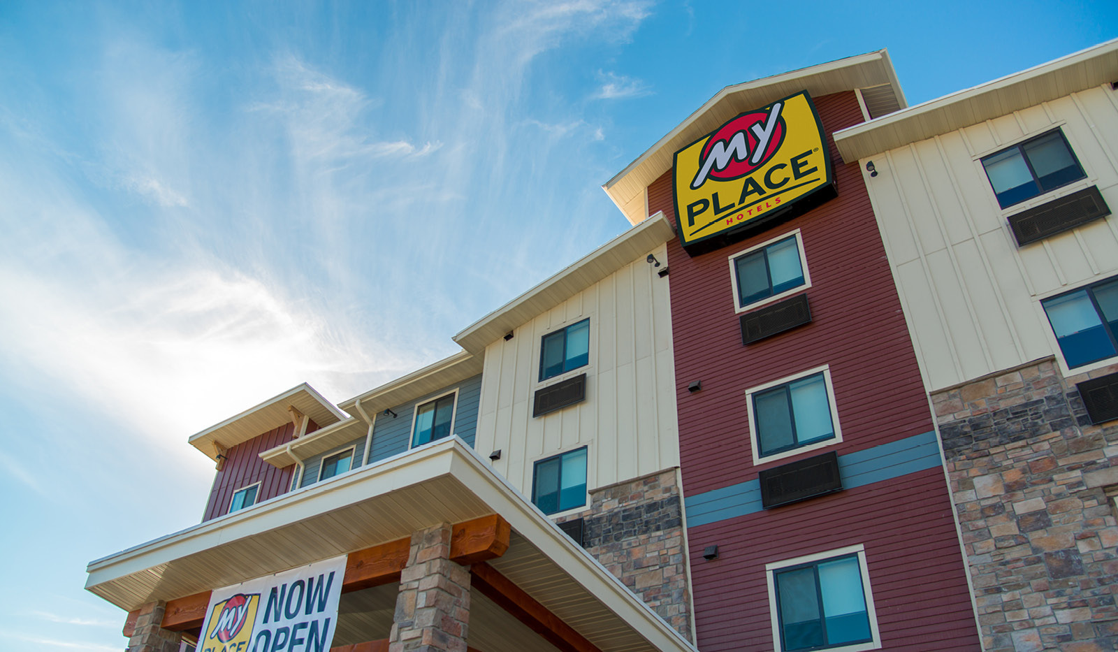 Top half of exterior of My Place Hotel-Independence, MO with sun behind the hotel.