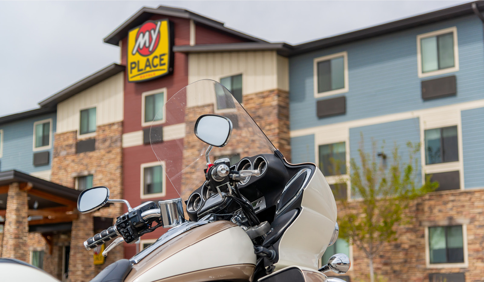 Exterior of My Place Hotel-Billings, MT with a motorcycle in focus in the foreground.