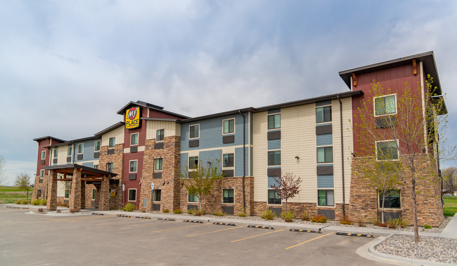 Exterior of My Place Hotel-Billings, MT under a cloudy sky.
